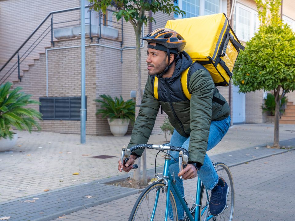 A delivery courier cycling through the city